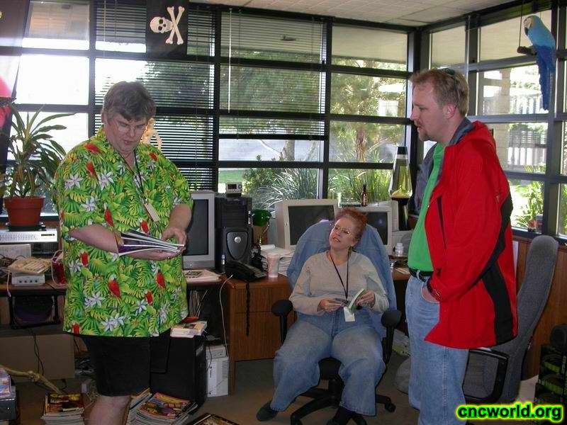 Mike Legg, Maria Legg, and Ted Morris confer in Mike's office as he begins to pack up for the move to LA.
